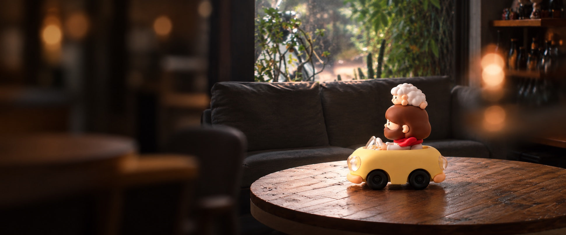 Jesus and a little lamb in a yellow car, seen from the side on a round wooden table in a quiet café